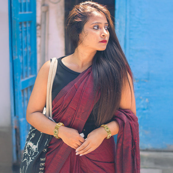 Outdoor model wearing an Indian kada bangle bracelet set with intricate gold-plated filigree.
