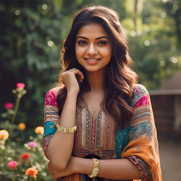 Model in red saree wearing Rajasthani kada bangle set with a pearl edge and gold-tone finish.
