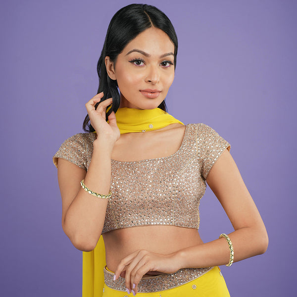 Close-up portrait of a model wearing gold Kundan teardrop bangles for festive celebrations.
