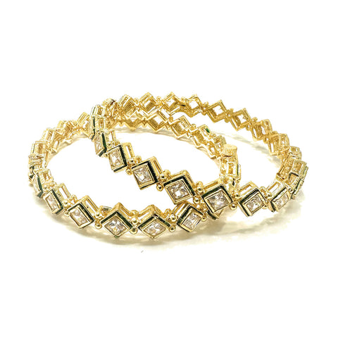 Model wearing gold-plated square Kundan bangles with green enamel accents and a black top.
