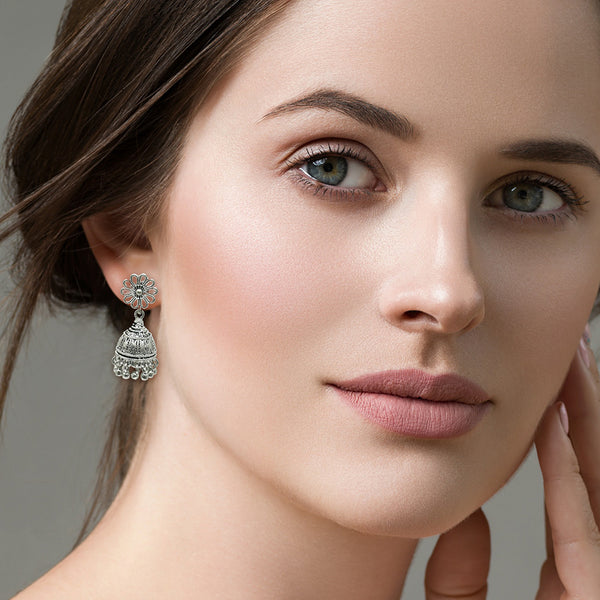Close-up of oxidized silver leaf engraving and bead fringe detail on handmade jhumka earrings
